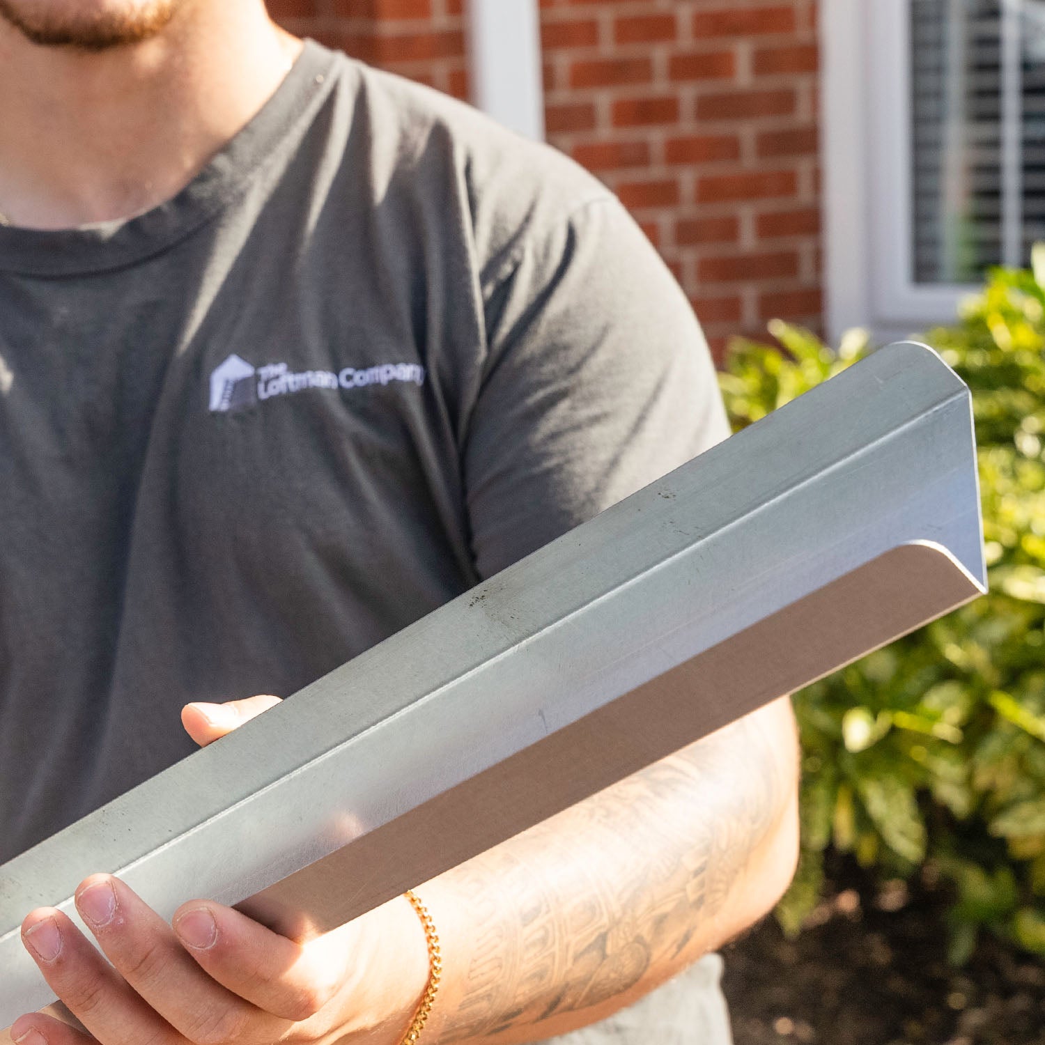 Loft installer holding Loft-Trac Steel Cross Beam — Loft-Trac