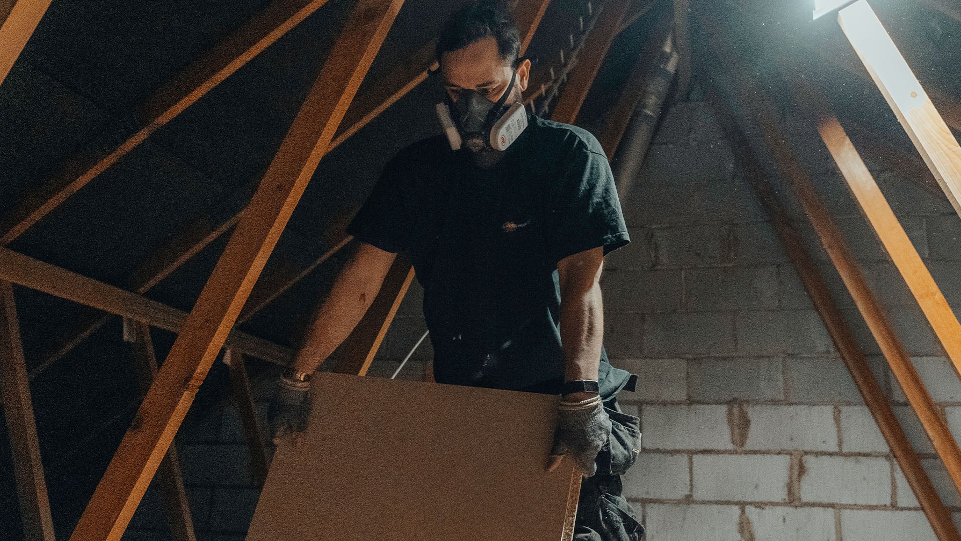 Loft installer lifting floorboard in loft — Loft-Trac